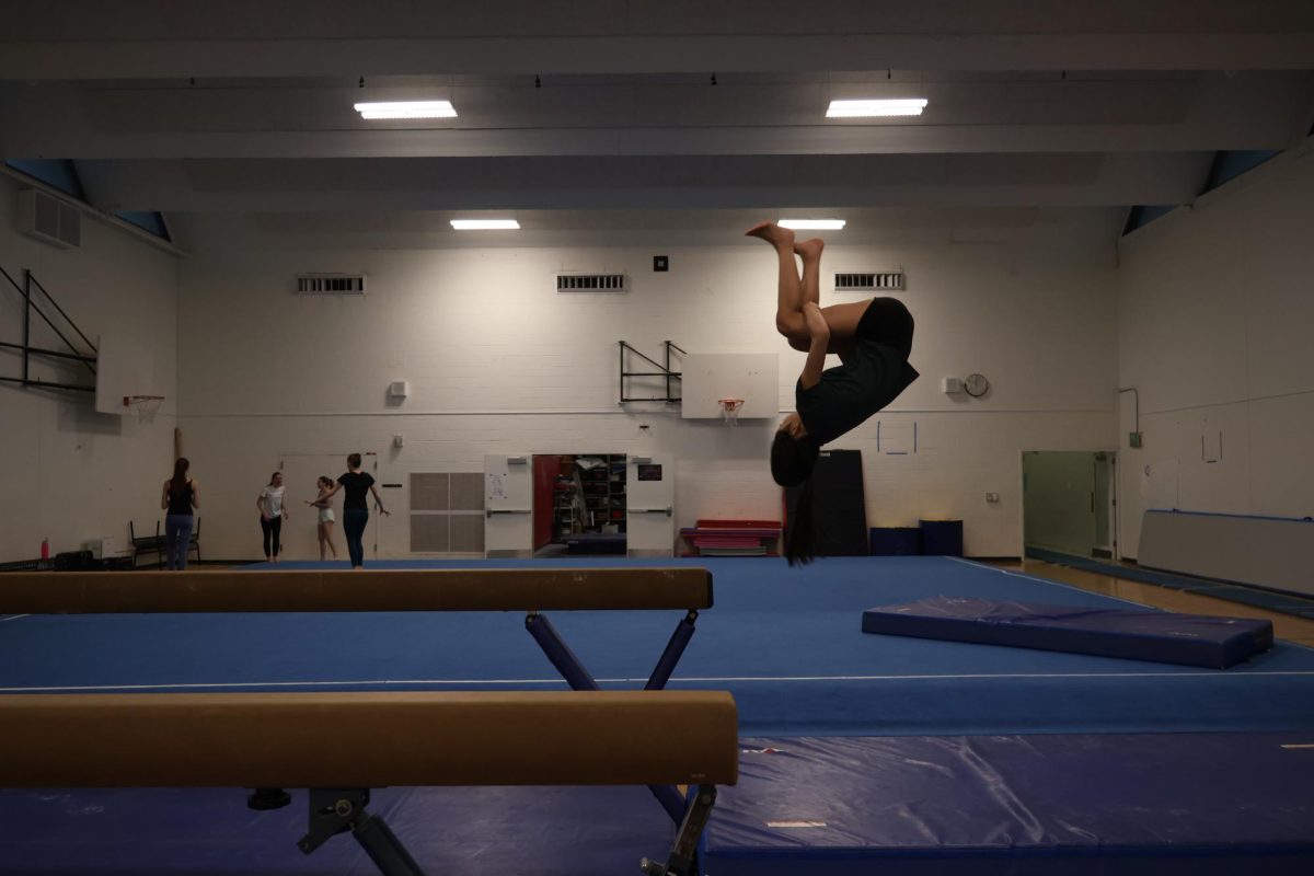 Gymnast practices her dismount off of the beam to perfect her routine