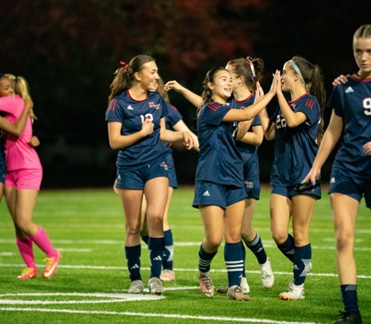 Women's senior varsity players celebrate win.