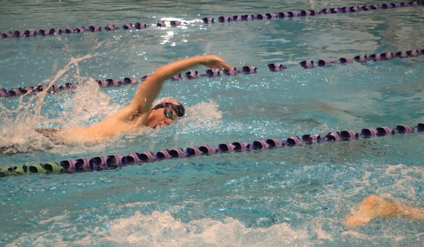 Men's swim practices freestyle quickly down his lane.